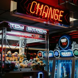 Engaging arcade scene featuring neon lights, claw machines, and a bustling atmosphere.